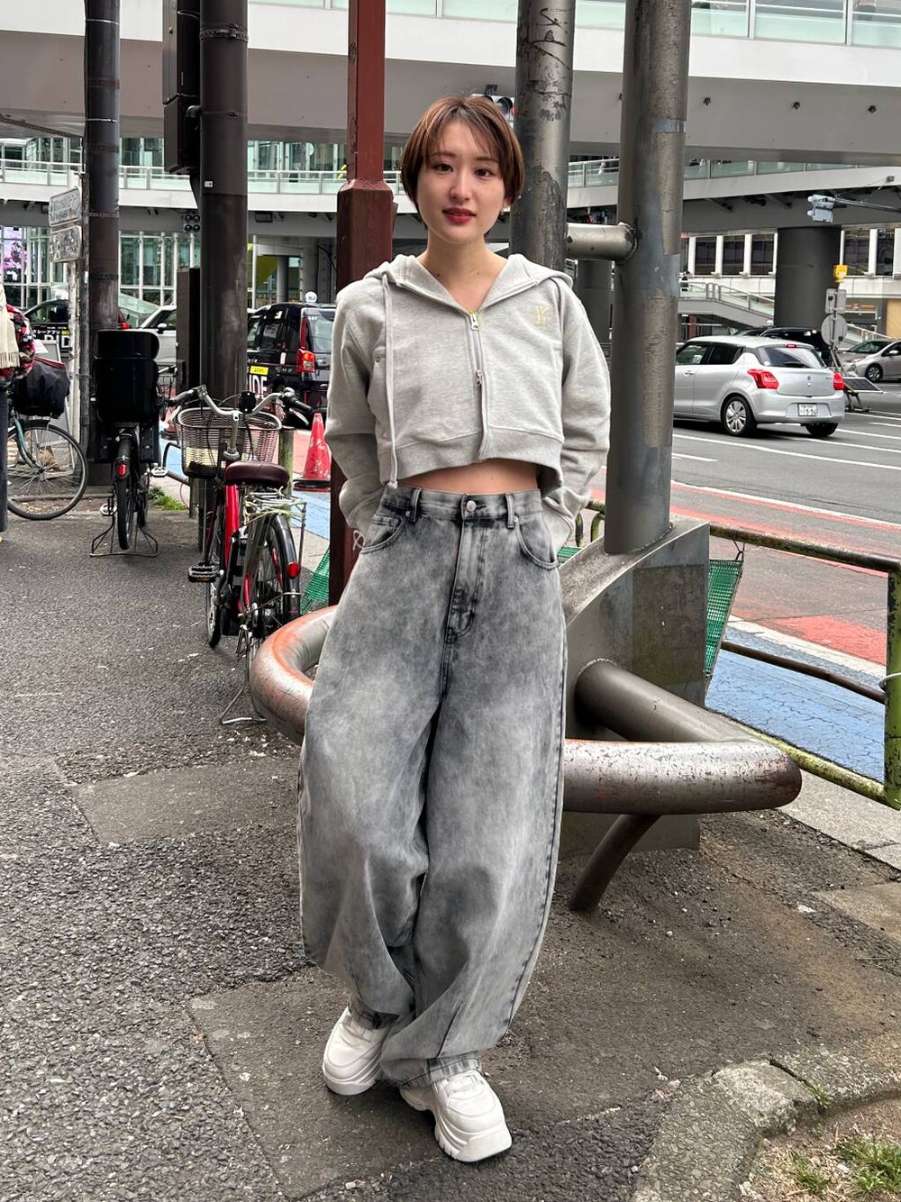 グレー系のパーカー、ブラック系のデニムパンツを着用したレディースの春コーディネートの1枚目の写真