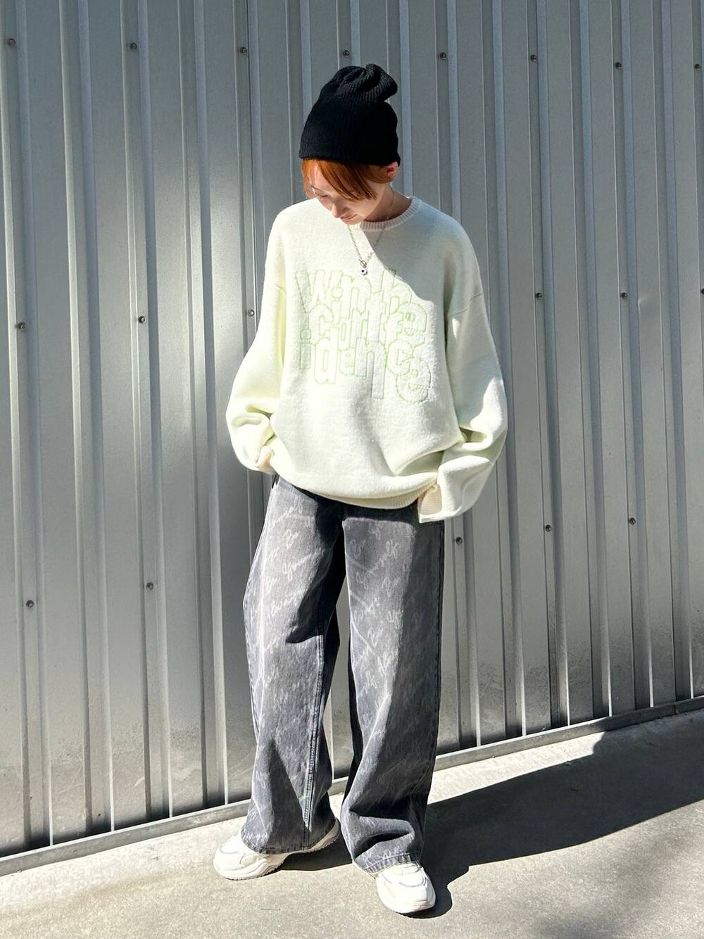 ブラック系のデニムパンツ、ホワイト系のニット/セーター、ブラック系のニットキャップ/ビーニーを着用したレディースの冬コーディネートの1枚目の写真