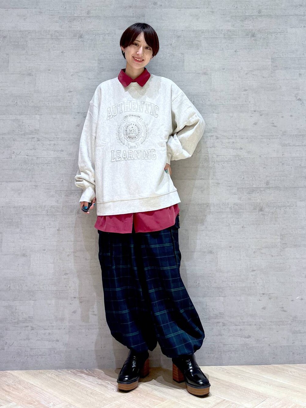 ベージュ系のスウェット、レッド系のシャツ/ブラウス、ブルー系のカーゴパンツを着用したレディースの冬コーディネートの1枚目の写真