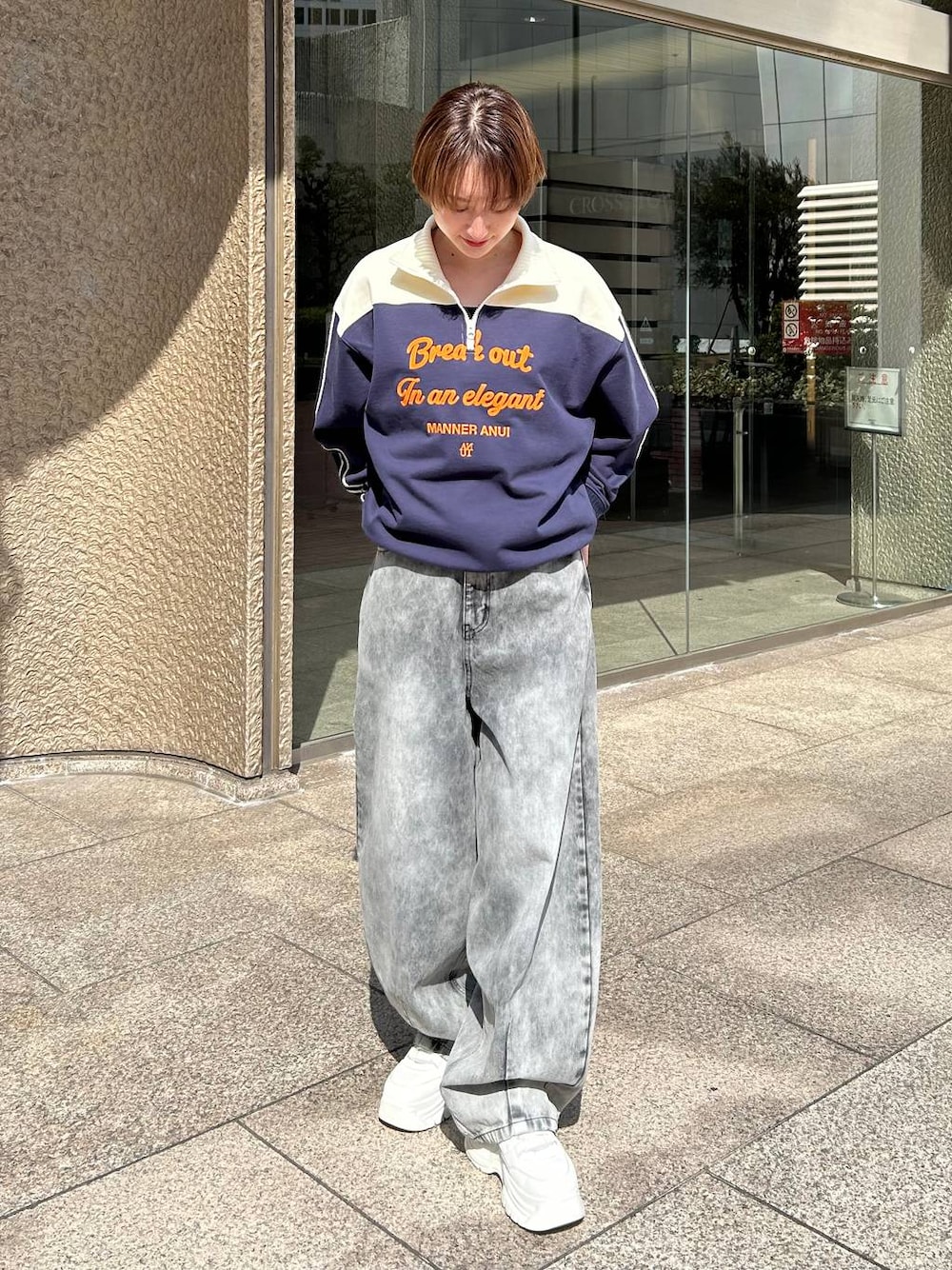 ブルー系のスウェット、ブラック系のデニムパンツを着用したレディースの春コーディネートの1枚目の写真