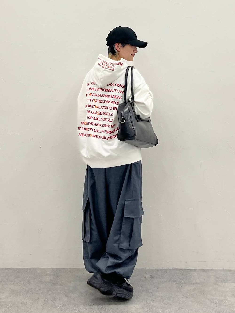 ブラック系のスニーカー、グレー系のカーゴパンツ、ブラック系のボストンバッグを着用したレディースの春コーディネートの1枚目の写真