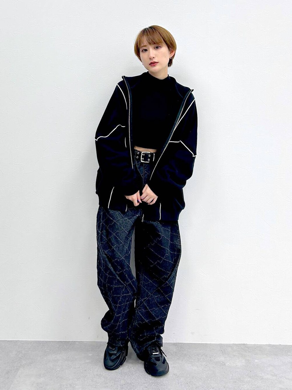 ブラック系のスウェット、ブラック系のデニムパンツ、ブラック系のベルトを着用したレディースの冬コーディネートの1枚目の写真