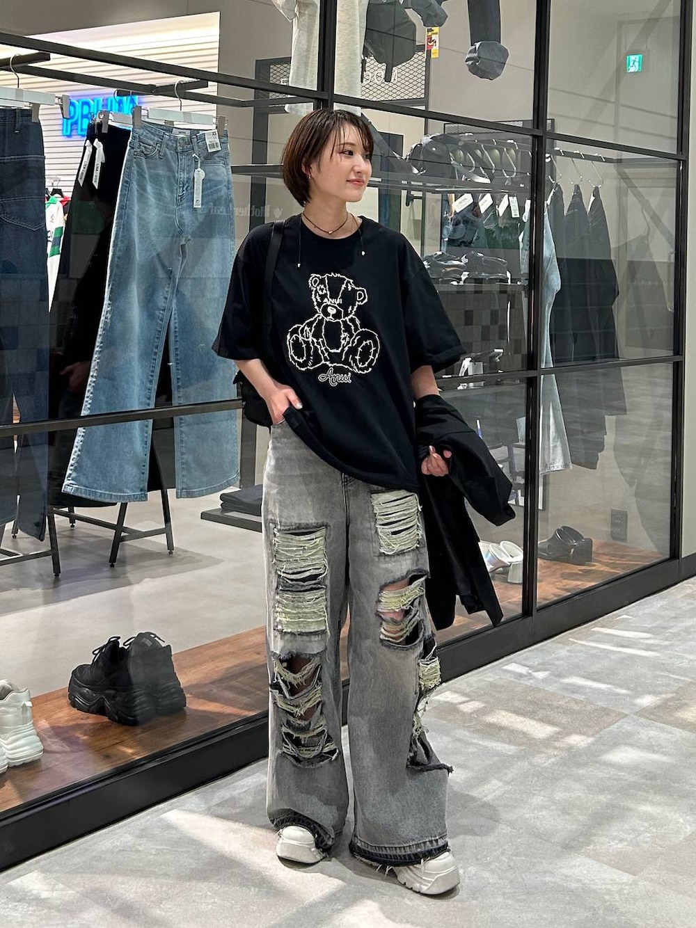 ブラック系のショルダーバッグ、ブラック系のテーラードジャケット、ブラック系のデニムパンツを着用したレディースの春コーディネートの1枚目の写真