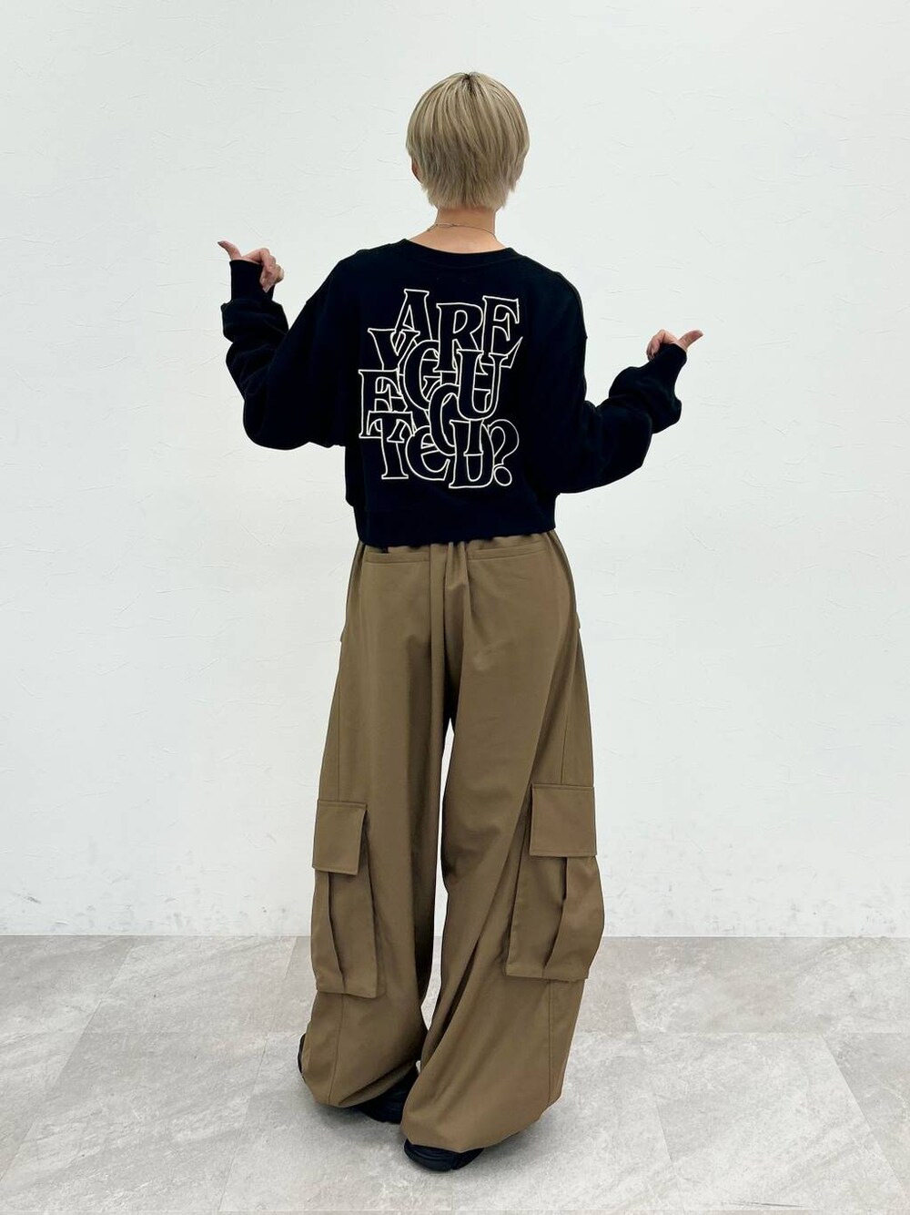 ブラック系のスウェット、ベージュ系のカーゴパンツ、シルバー系のネックレスを着用したレディースの秋コーディネートの1枚目の写真