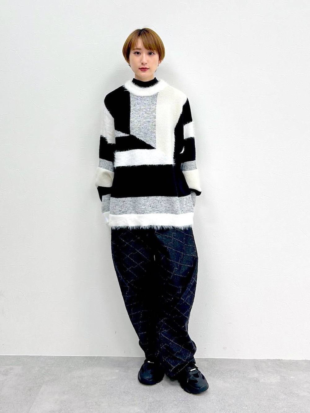ブラック系のデニムパンツ、グレー系のニット/セーターを着用したレディースの冬コーディネートの1枚目の写真