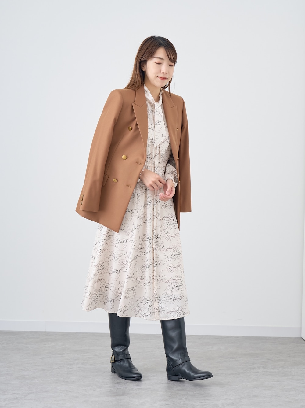 イエロー系のテーラードジャケット、ホワイト系のワンピースを着用したレディースの秋コーディネートの1枚目の写真