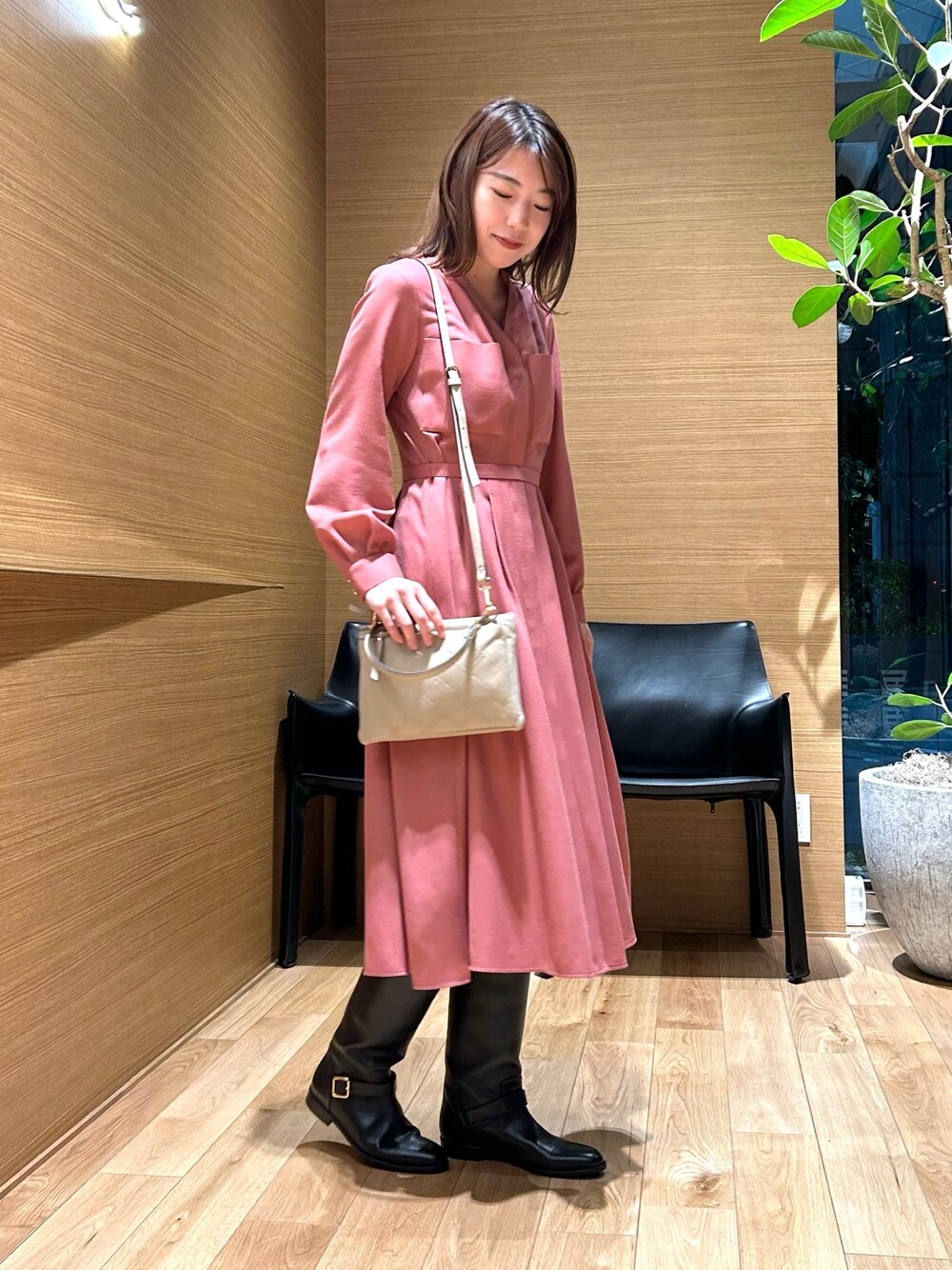 ピンク系のワンピース、ベージュ系のバックパック/リュックを着用したレディースの秋コーディネートの1枚目の写真