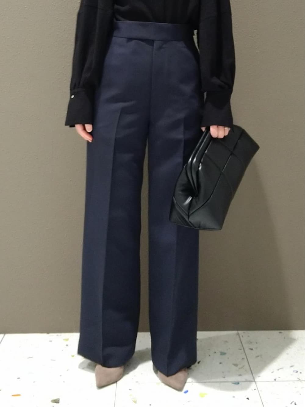 ブラック系のシャツ/ブラウス、ブルー系のスラックス、ブラック系のクラッチバッグを着用したレディースの冬コーディネートの4枚目の写真