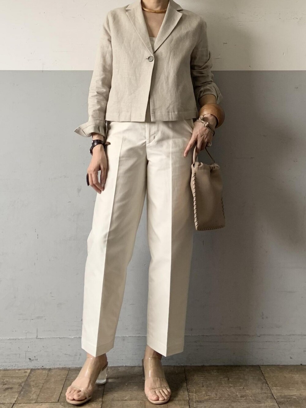 ホワイト系のテーラードジャケット、ホワイト系のチノパンツ、ベージュ系のバッグを着用したレディースの春コーディネートの2枚目の写真