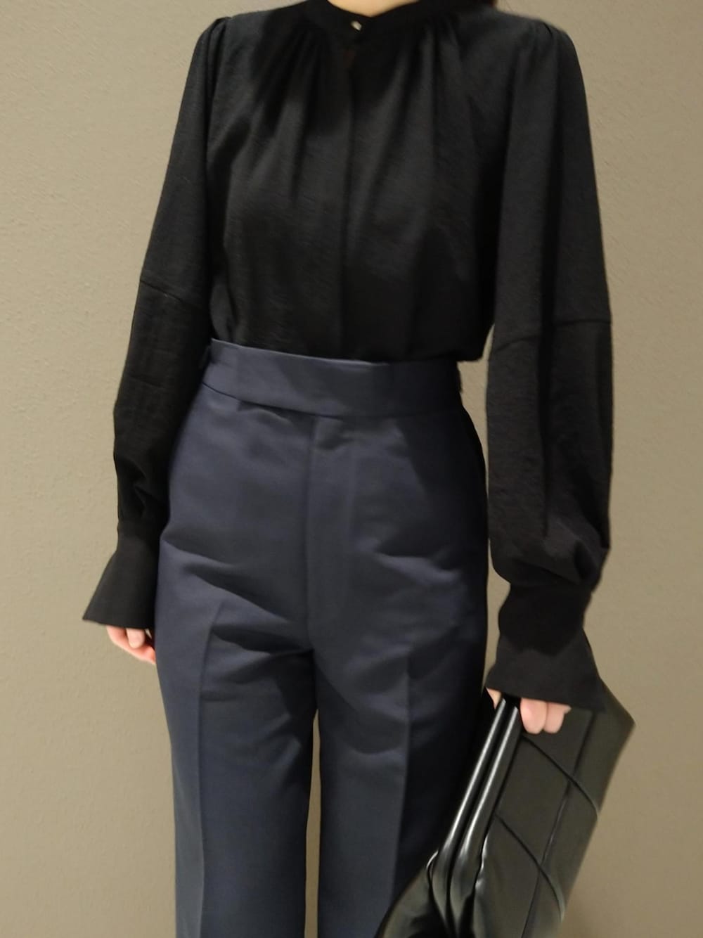 ブラック系のシャツ/ブラウス、ブルー系のスラックス、ブラック系のクラッチバッグを着用したレディースの冬コーディネートの3枚目の写真