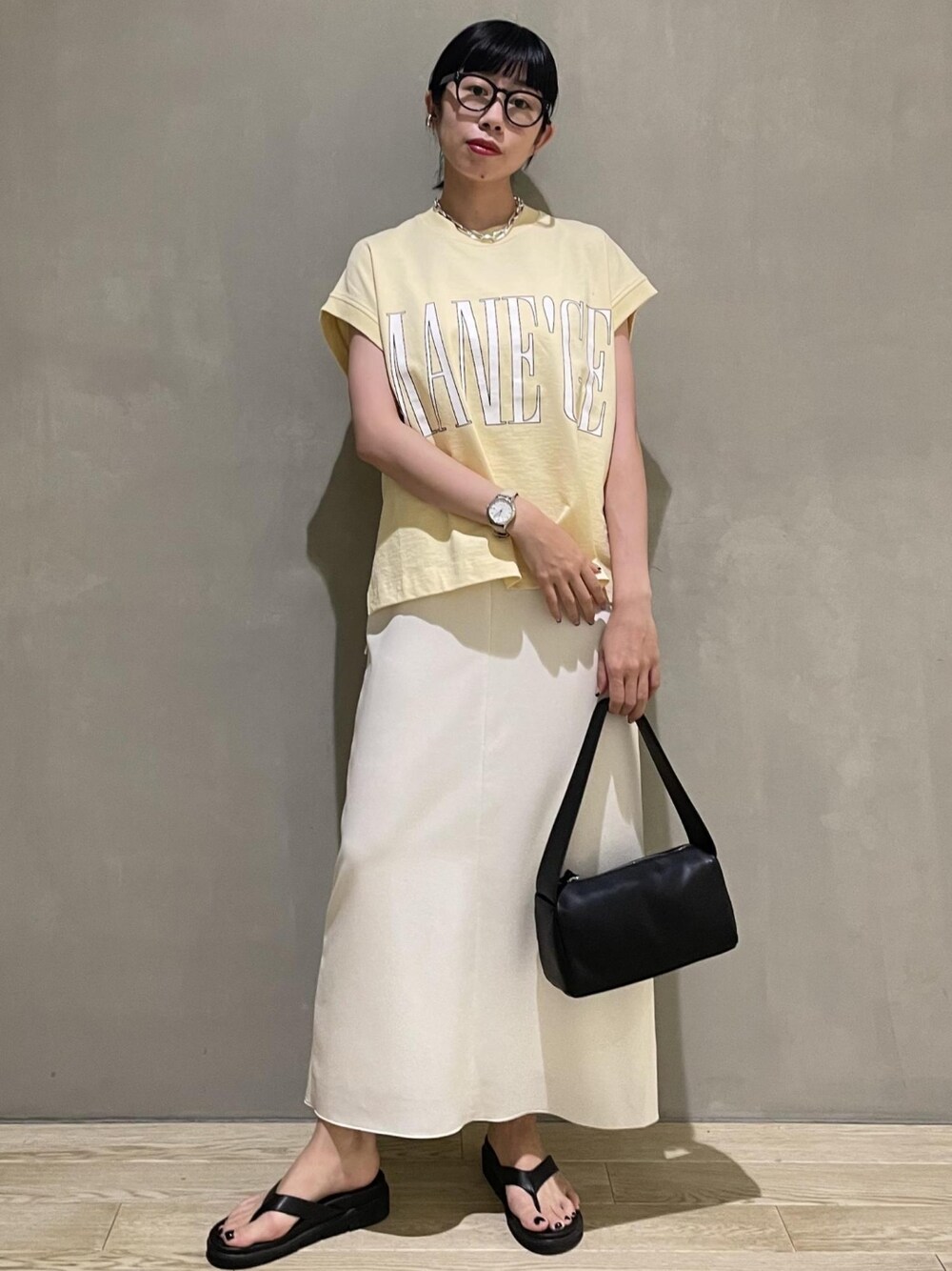 ホワイト系のワンピース、ベージュ系のTシャツ/カットソー、ブラック系のサンダルを着用したレディースの夏コーディネートの1枚目の写真