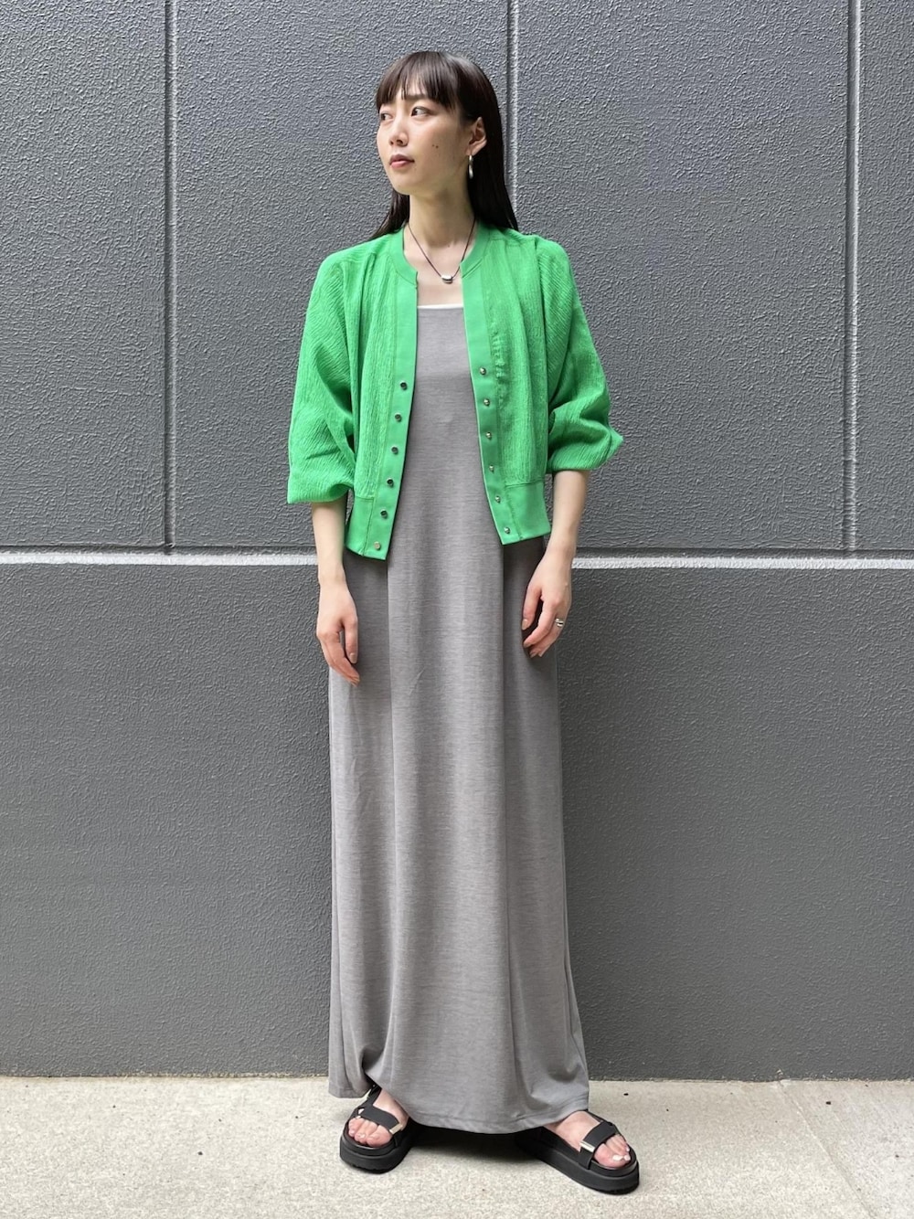 グリーン系のカーディガン/ボレロ、グレー系のワンピース、ブラック系のサンダルを着用したレディースの夏コーディネートの1枚目の写真