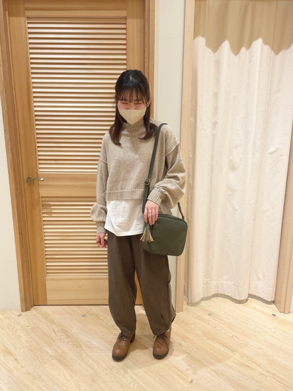 ベージュ系のニット/セーター、グリーン系のショルダーバッグ、ブラウン系のその他パンツを着用したレディースの秋コーディネートの1枚目の写真