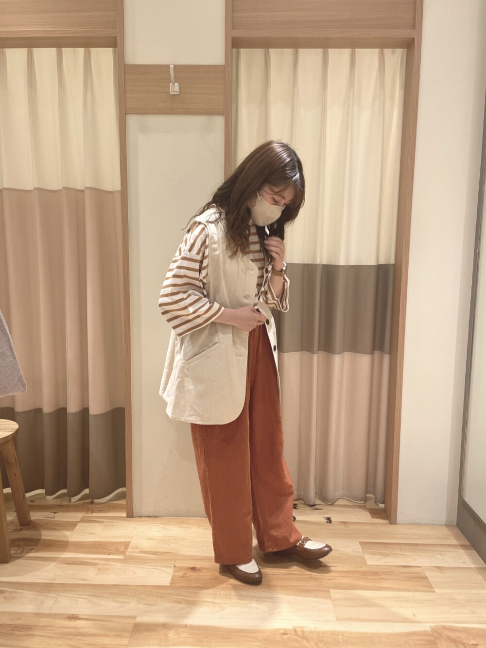 オレンジ系のその他パンツ、ブラウン系のTシャツ/カットソー、ベージュ系のベストを着用したレディースの春コーディネートの1枚目の写真