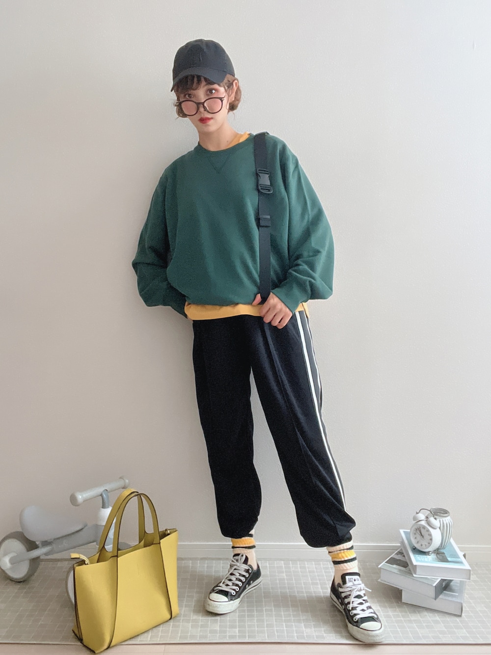 グリーン系のスウェット、ブラック系のパンツを着用したレディースの夏コーディネートの1枚目の写真