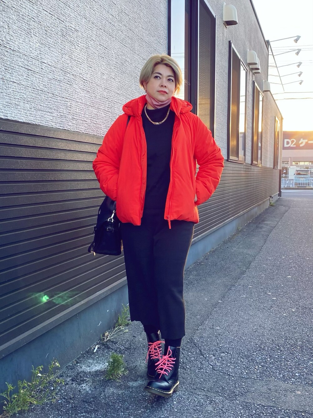 レッド系のダウンジャケット/コート、ブラック系のブーツを着用したレディースの冬コーディネートの1枚目の写真