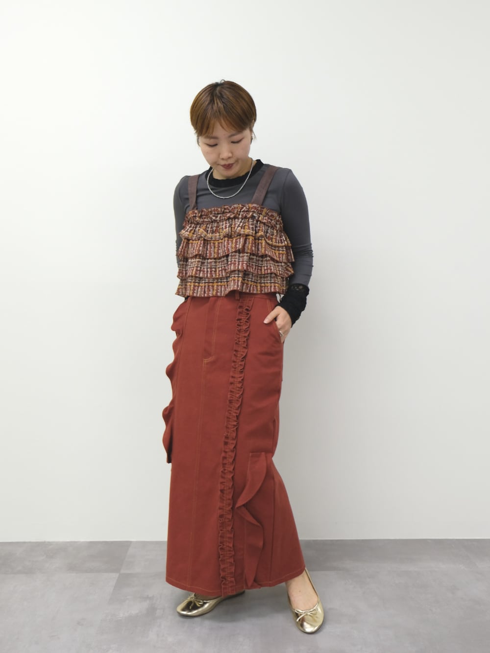 グレー系のTシャツ/カットソー、ブラウン系のその他トップス、レッド系のスカートを着用したレディースの秋コーディネートの1枚目の写真