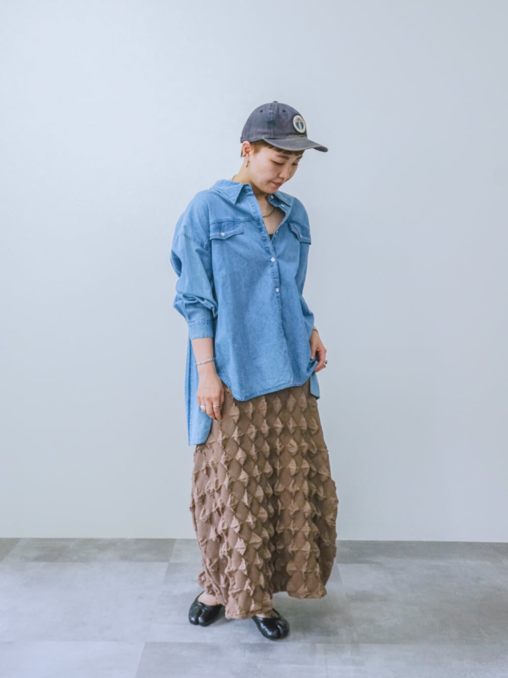 ブラウン系のスカートを着用したレディースの夏コーディネートの1枚目の写真