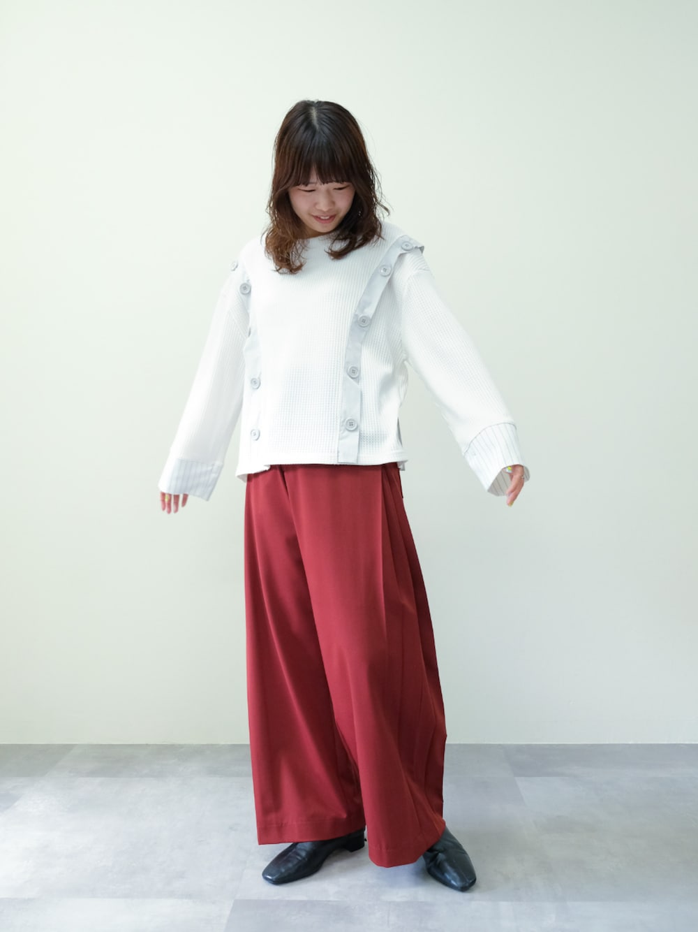 ホワイト系のTシャツ/カットソー、レッド系のスラックスを着用したレディースの秋コーディネートの1枚目の写真