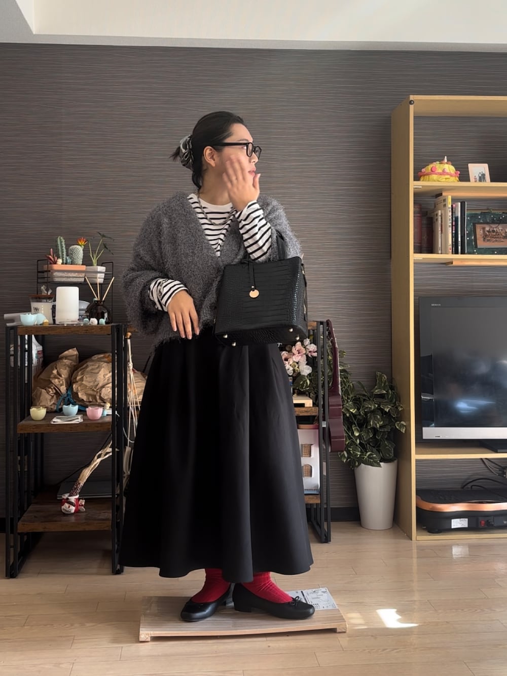 ブラック系のバレエシューズ、ブラック系のスカート、ブラック系のバッグを着用したレディースの冬コーディネートの1枚目の写真