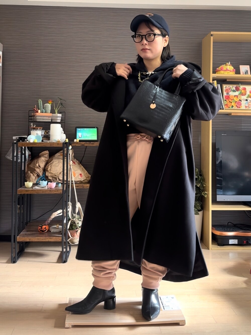 ブラック系のジャケット/アウター、ピンク系のスウェットパンツ、ブラック系のバッグを着用したレディースの冬コーディネートの1枚目の写真