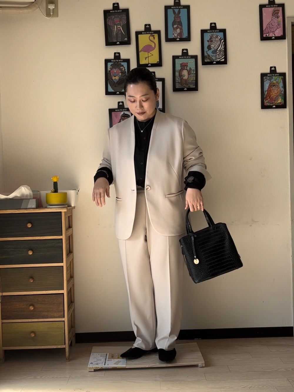 ベージュ系のスーツジャケット、ベージュ系のスーツパンツ、ブラック系のシャツ/ブラウスを着用したレディースの冬コーディネートの1枚目の写真