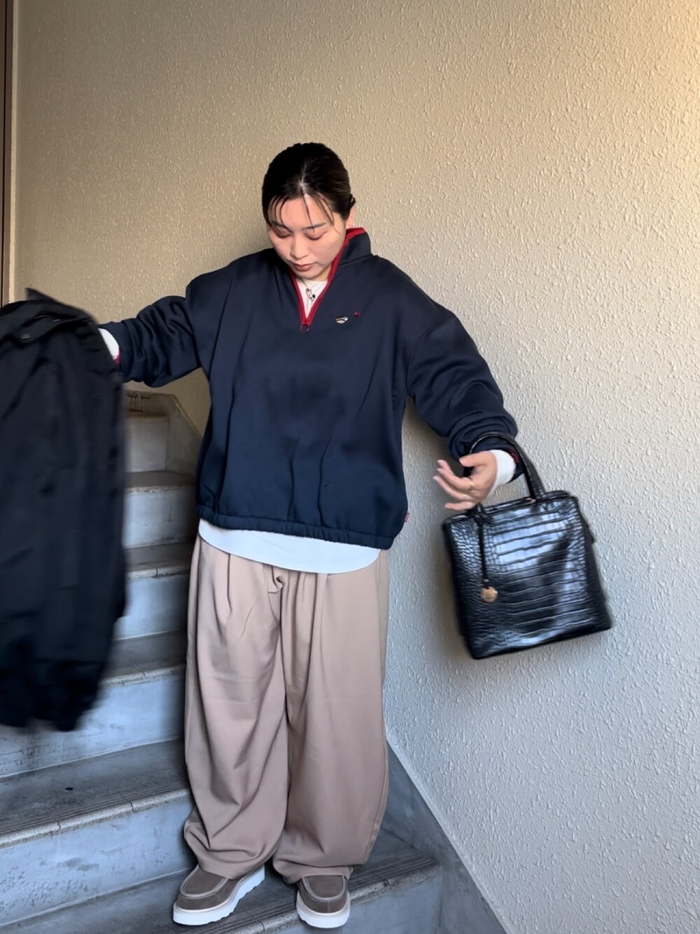 ベージュ系のブーツ、ベージュ系のパンツ、ブルー系のスウェットを着用したレディースの冬コーディネートの1枚目の写真