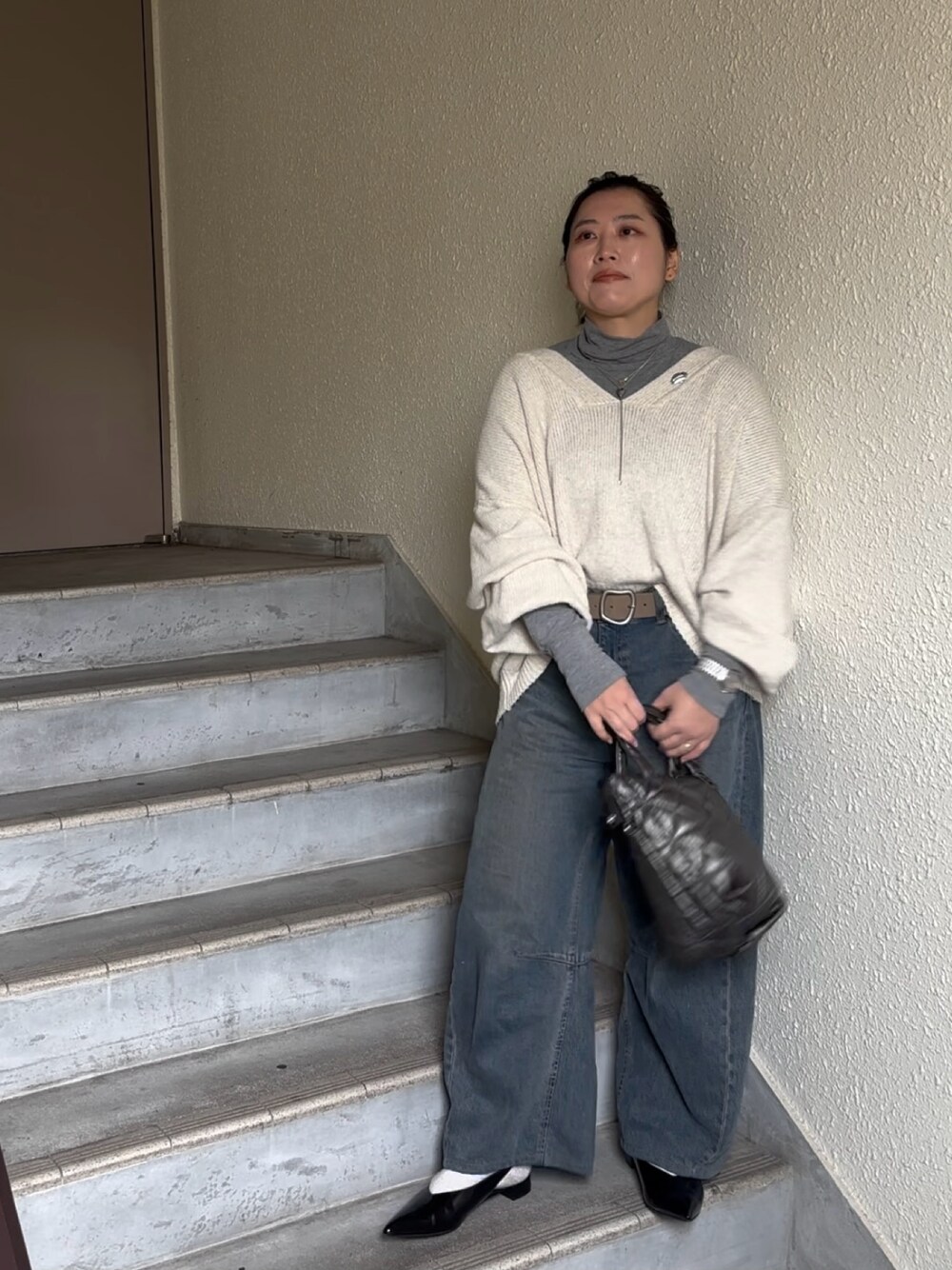 ホワイト系のニット/セーター、ブルー系のデニムパンツ、ブラック系のパンプスを着用したレディースの春コーディネートの1枚目の写真