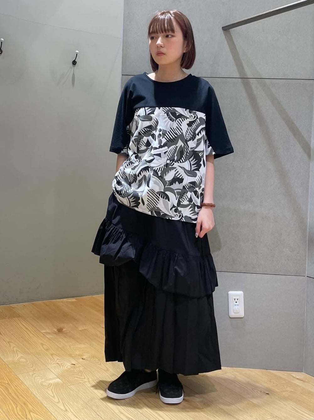 ブラック系のTシャツ/カットソー、ブラック系のスカート、ブラック系のその他シューズを着用したレディースの春コーディネートの1枚目の写真