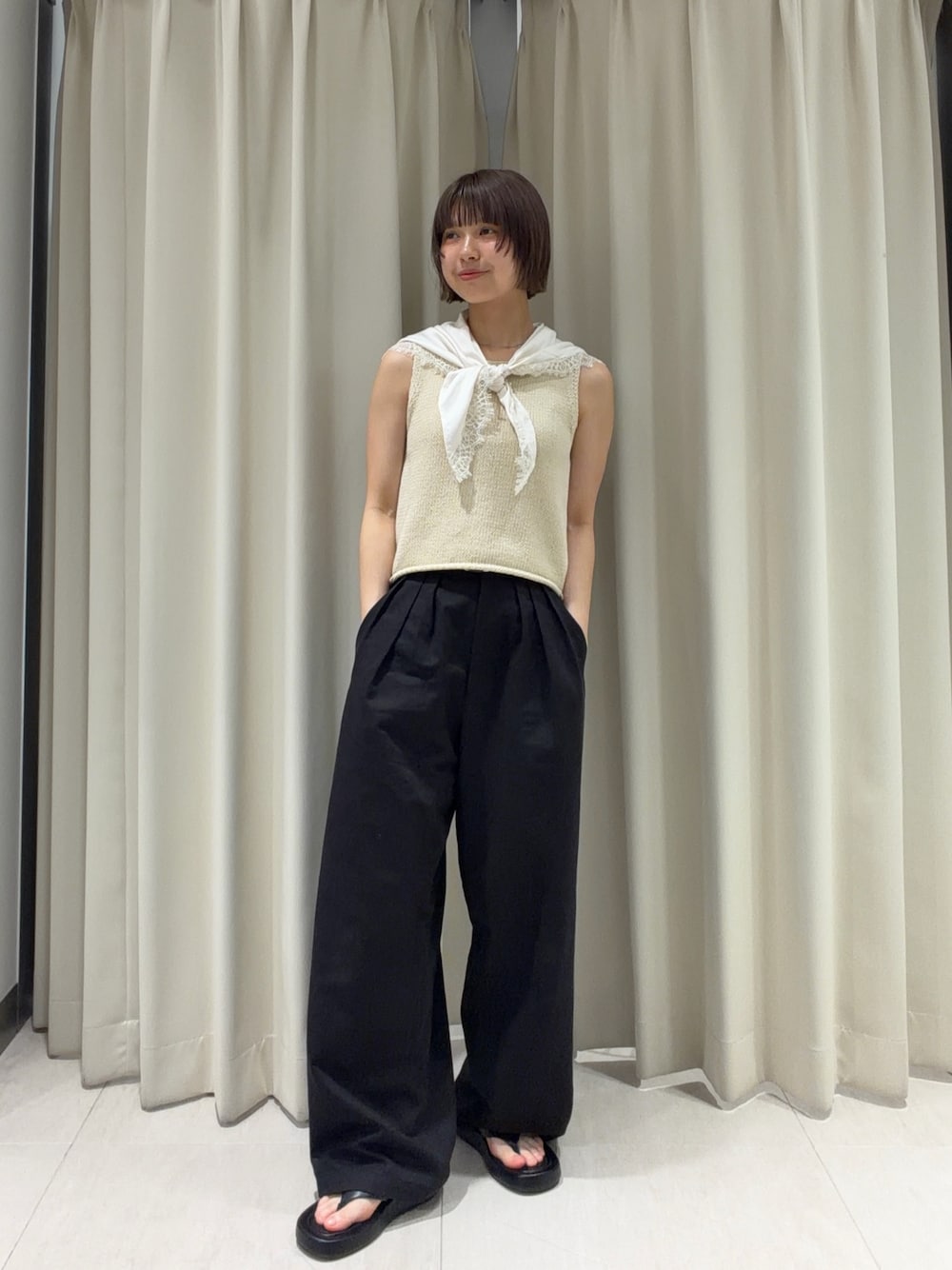 ブラック系のその他パンツ、ブラック系のサンダル、ホワイト系のベストを着用したレディースの夏コーディネートの1枚目の写真