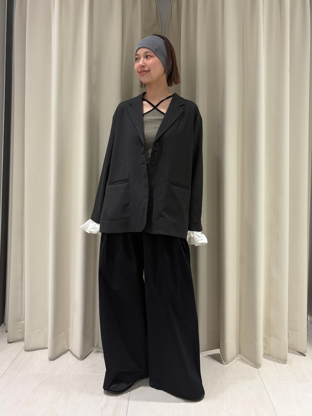 グレー系のその他アウター、ブラック系のその他パンツ、ベージュ系のキャミソールを着用したレディースの春コーディネートの1枚目の写真