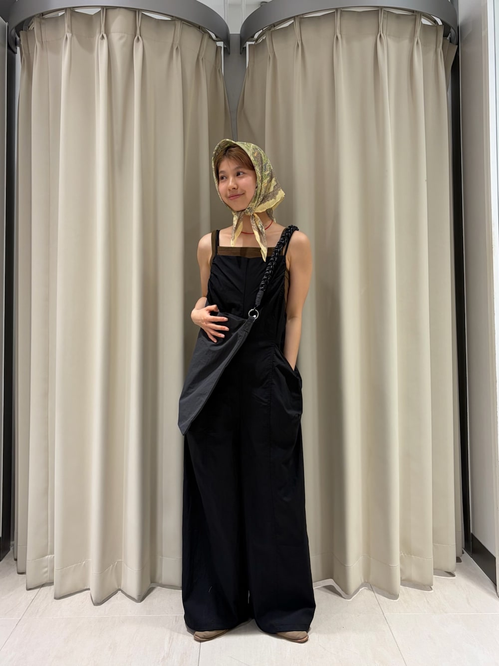 ブラック系のその他パンツ、グレー系のショルダーバッグ、グリーン系のタンクトップを着用したレディースの春コーディネートの1枚目の写真