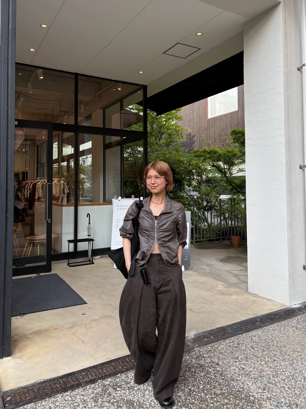 ブラウン系のその他パンツ、グレー系のブルゾン、レッド系のネックレスを着用したレディースの春コーディネートの1枚目の写真