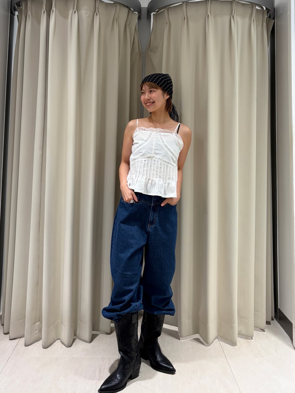 ブルー系のデニムパンツ、ホワイト系のキャミソールを着用したレディースの夏コーディネートの1枚目の写真