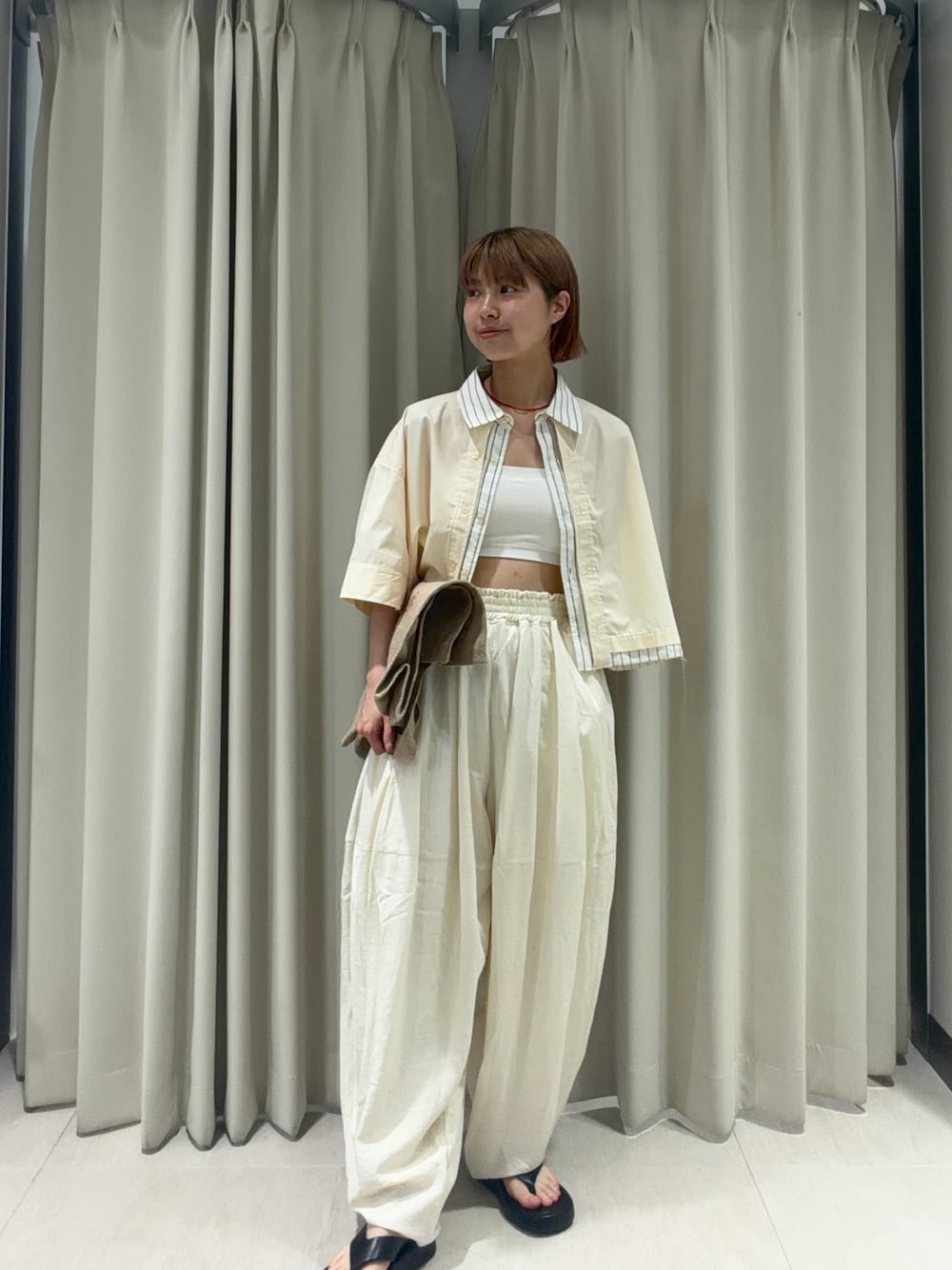 イエロー系のシャツ/ブラウス、ホワイト系のその他パンツ、ブラック系のサンダルを着用したレディースの夏コーディネートの1枚目の写真