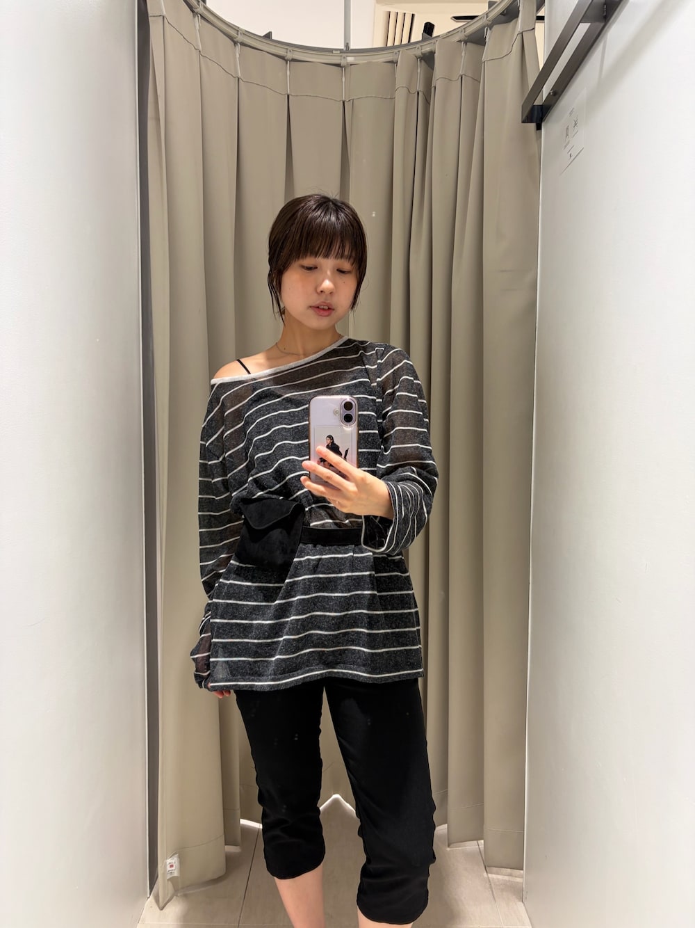 グレー系のニット/セーター、ブラック系のその他パンツ、ブラック系のボディバッグ/ウエストポーチを着用したレディースの秋コーディネートの1枚目の写真
