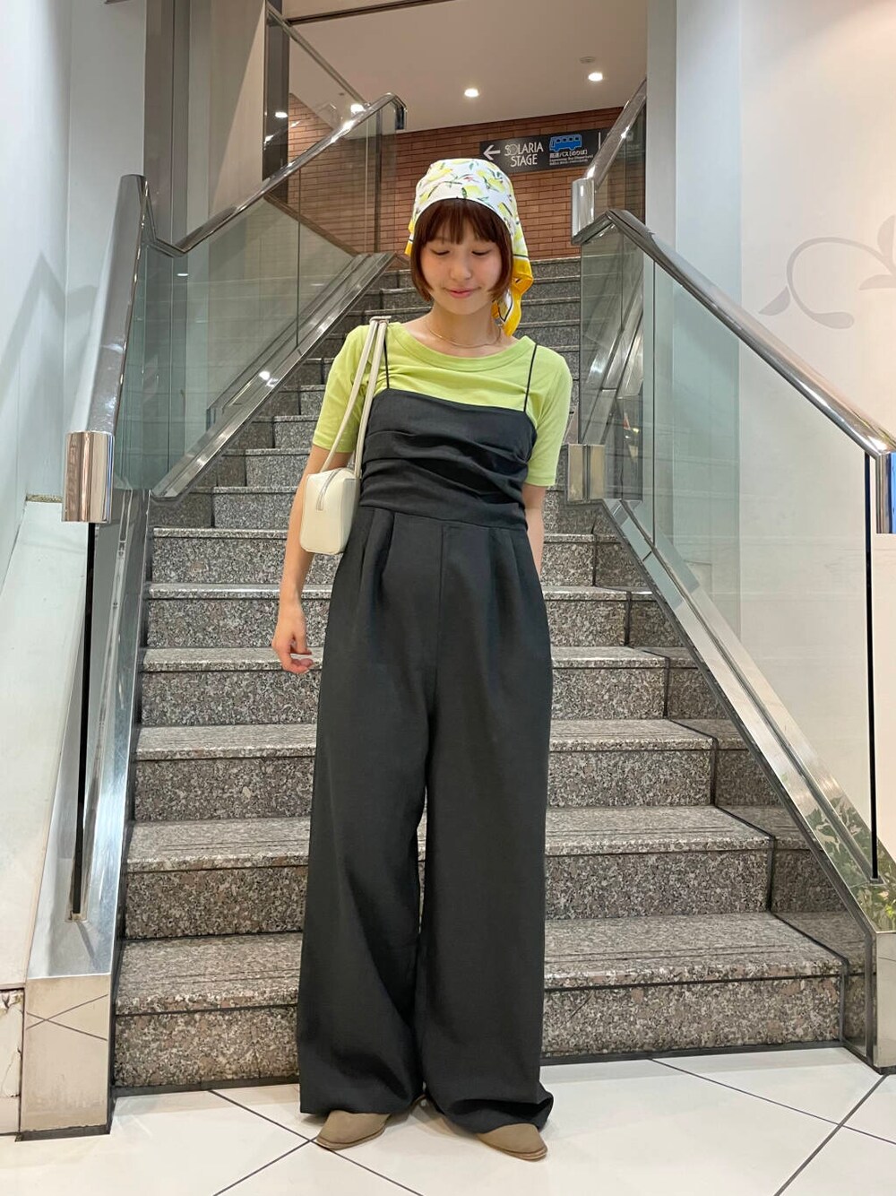 ホワイト系のショルダーバッグ、ベージュ系のその他シューズ、グリーン系のTシャツ/カットソーを着用したレディースの夏コーディネートの1枚目の写真
