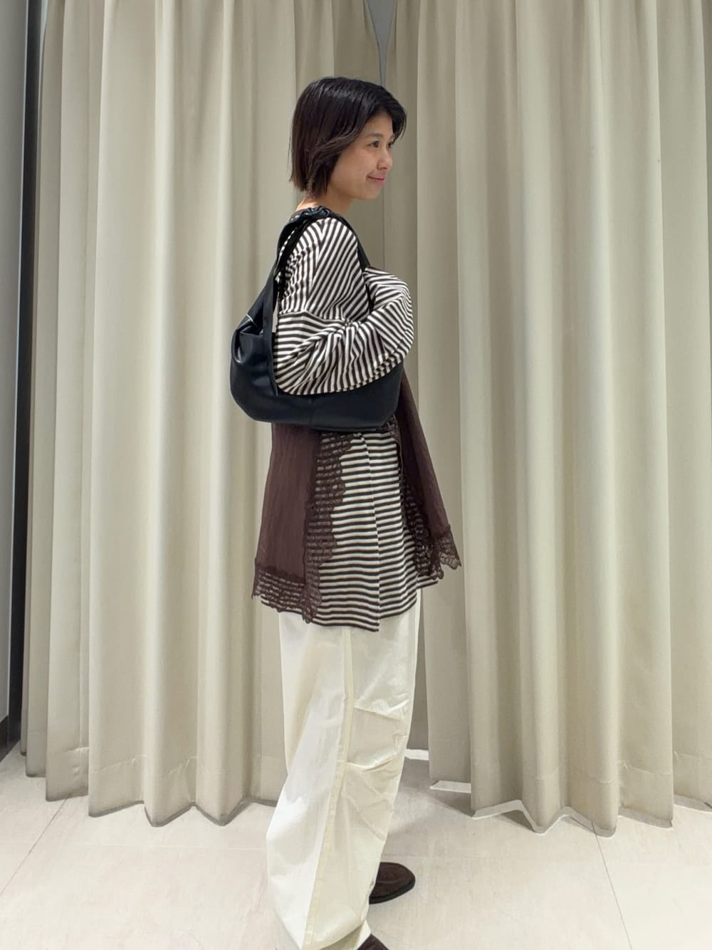 ブラウン系のキャミソール、ブラウン系のニット/セーター、ホワイト系のその他パンツを着用したレディースの春コーディネートの1枚目の写真