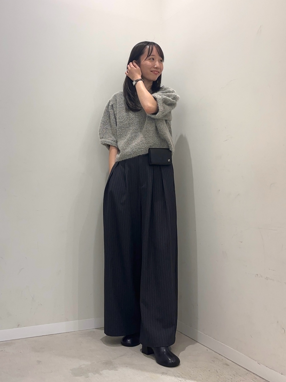 グレー系のニット/セーター、グレー系のその他パンツ、ブラック系のスリッポンを着用したレディースの夏コーディネートの1枚目の写真