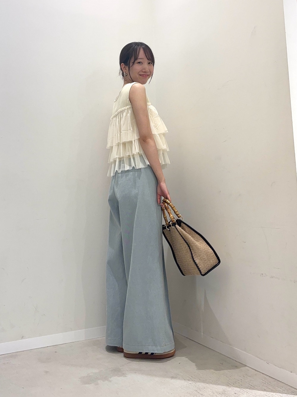 ホワイト系のニット/セーター、ブルー系のデニムパンツ、ブラック系のショルダーバッグを着用したレディースの春コーディネートの1枚目の写真