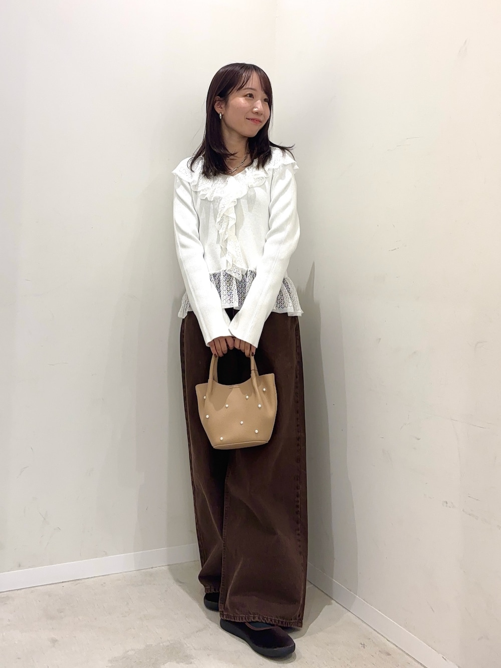 ホワイト系のニット/セーター、ブラウン系のデニムパンツ、ブラウン系のその他シューズを着用したレディースの秋コーディネートの1枚目の写真