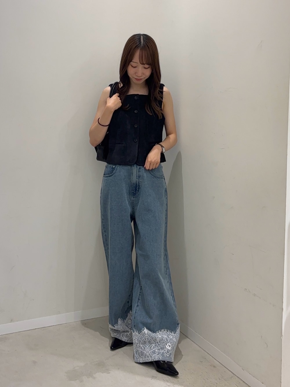 ブルー系のダウンベスト、ブルー系のデニムパンツ、ブラック系のパンプスを着用したレディースの夏コーディネートの1枚目の写真