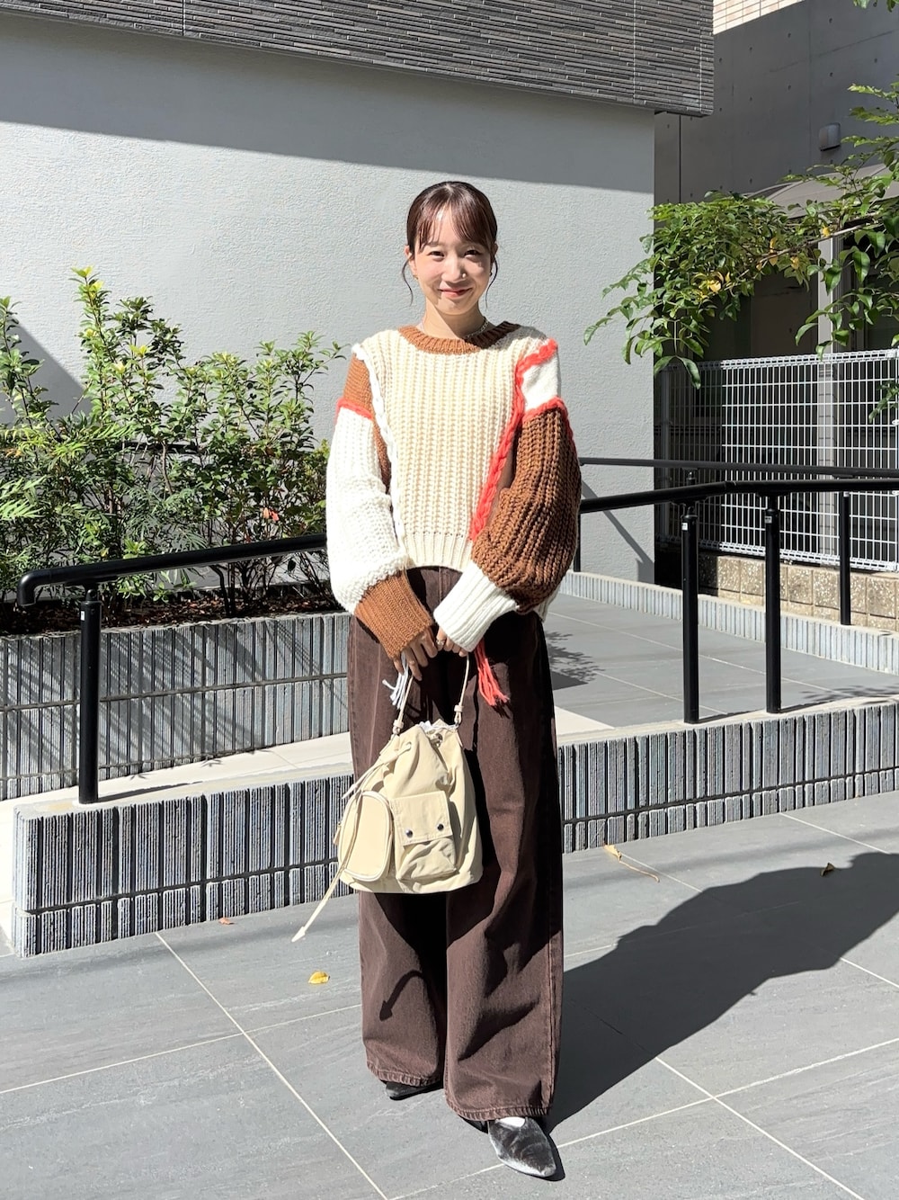 ブラウン系のニット/セーター、ブラウン系のデニムパンツ、グレー系のパンプスを着用したレディースの秋コーディネートの1枚目の写真