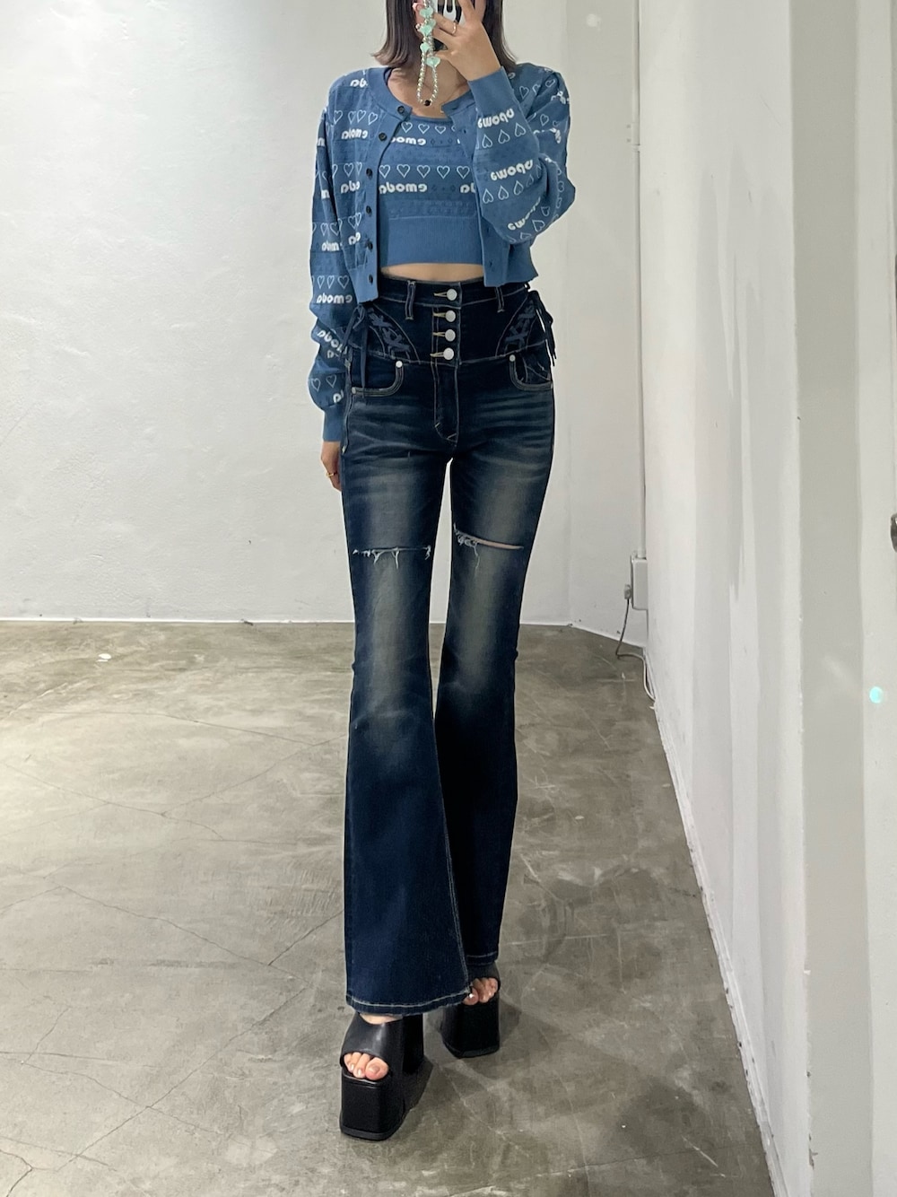 ブルー系のニット/セーター、ブルー系のデニムパンツ、ブラック系のサンダルを着用したレディースの冬コーディネートの1枚目の写真