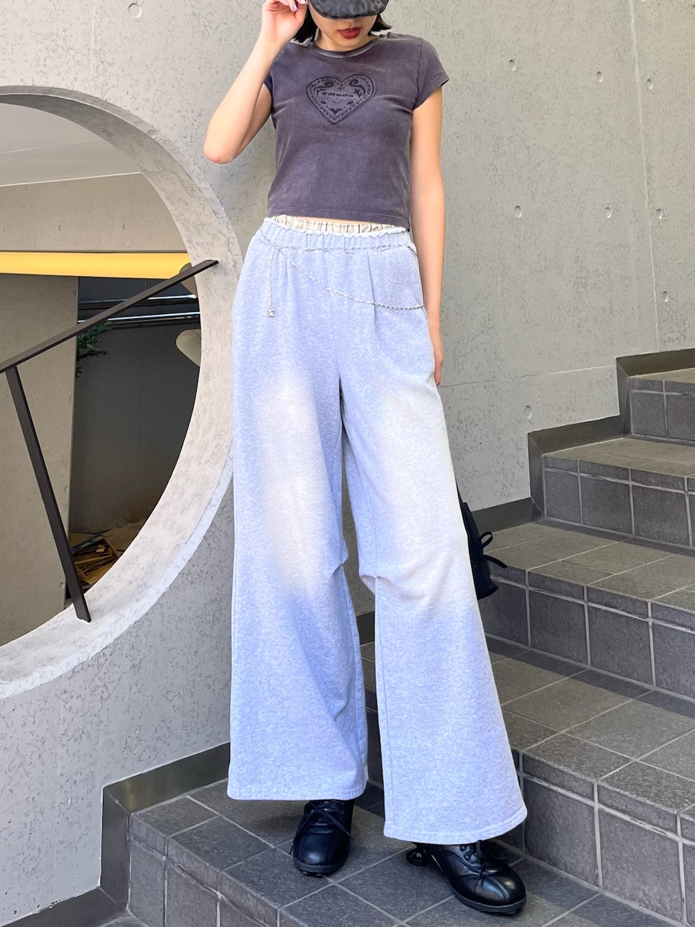 ブラック系のTシャツ/カットソー、ブラック系のスニーカー、グレー系のスウェットパンツを着用したレディースの春コーディネートの1枚目の写真