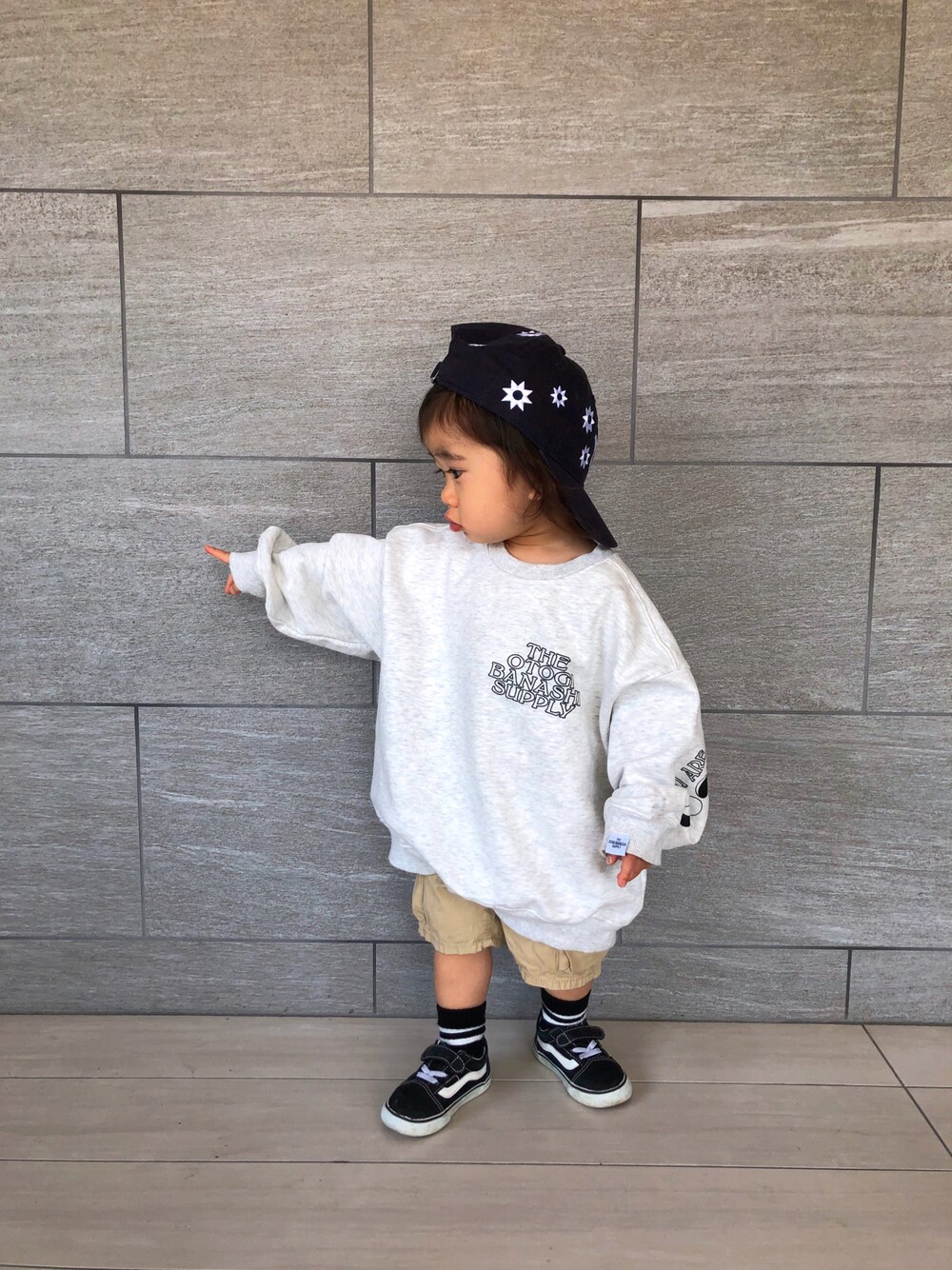 ホワイト系のスウェット、ベージュ系のチノパンツ、ブルー系のキャップを着用したキッズの春コーディネートの1枚目の写真