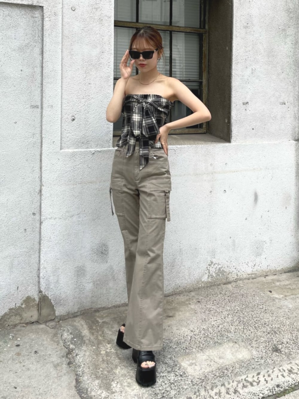 ベージュ系のカーゴパンツ、ブラック系のTシャツ/カットソー、ブラック系のブーツを着用したレディースの夏コーディネートの1枚目の写真