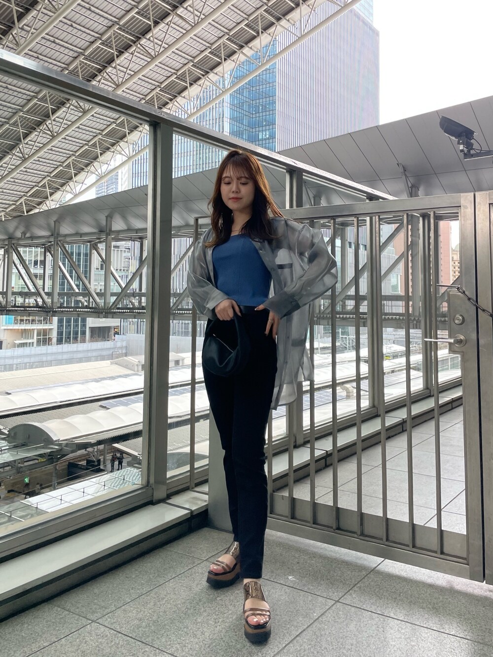 グレー系のシャツ/ブラウス、ブルー系のタンクトップ、ブラック系のハンドバッグを着用したレディースの春コーディネートの1枚目の写真