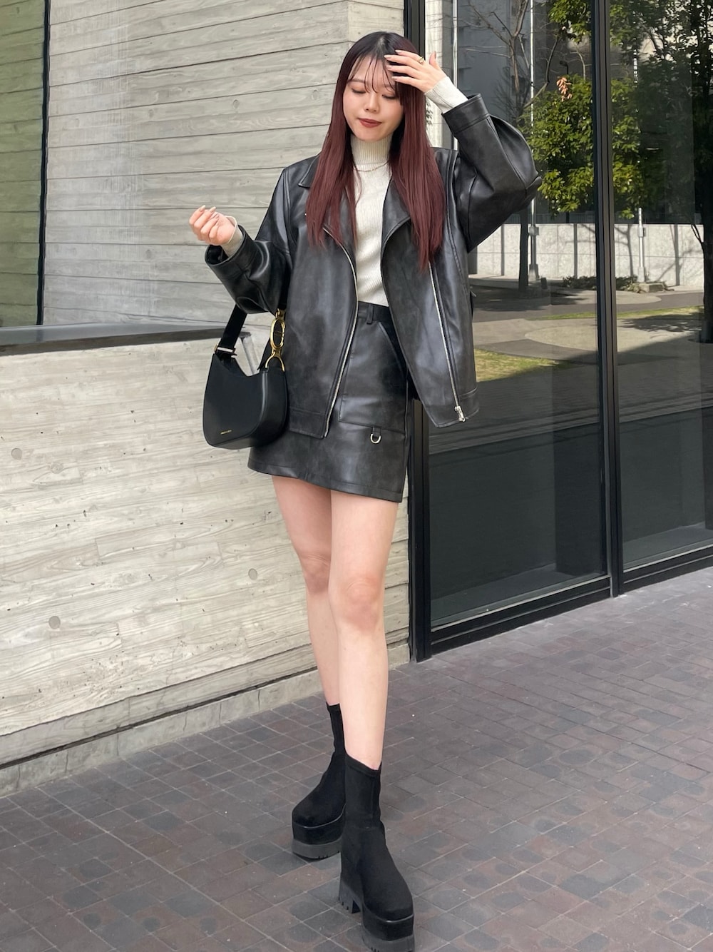 ブラック系のブルゾン、ブラック系のスカート、ホワイト系のニット/セーターを着用したレディースの冬コーディネートの1枚目の写真