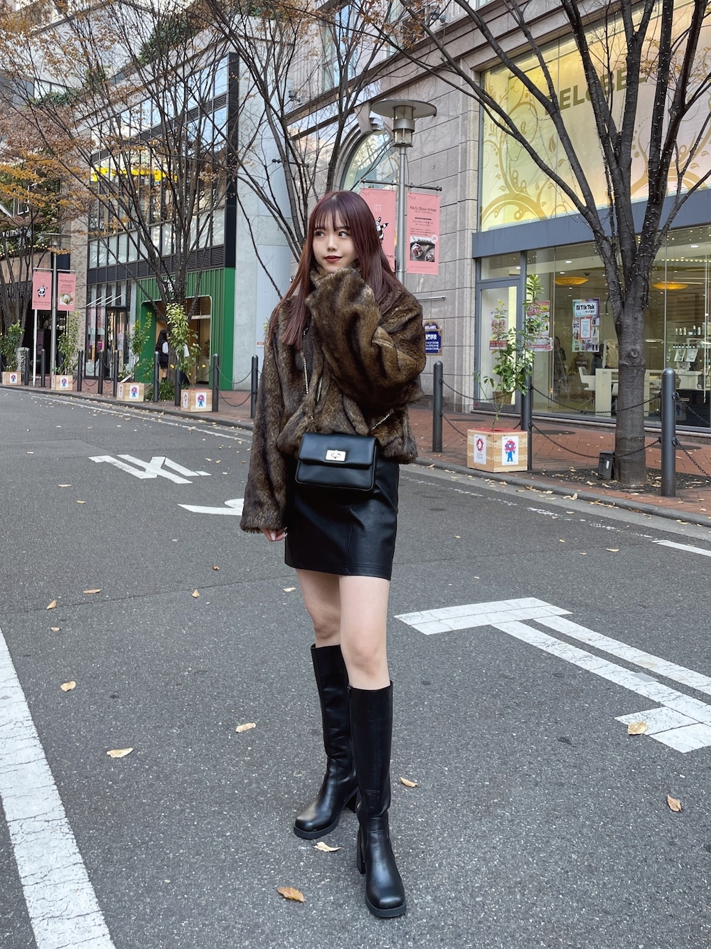 ブラック系のブーツ、ブラック系のスカート、レッド系のニット/セーターを着用したレディースの冬コーディネートの1枚目の写真